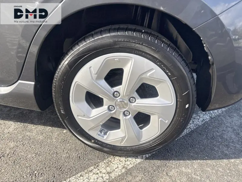 Gros plan sur la roue avant droite avec jante alu de la Suzuki Swift 1.2 Hybrid Mineral Gray Metal 2024.