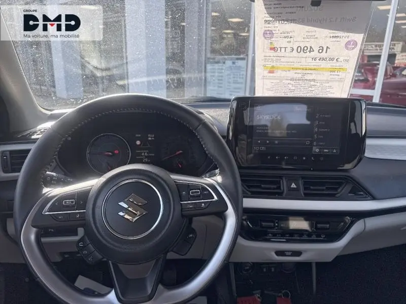 Vue intérieure centrée sur le volant cuir multifonction et l'écran tactile du tableau de bord de la Suzuki Swift gris Mineral Gray.
