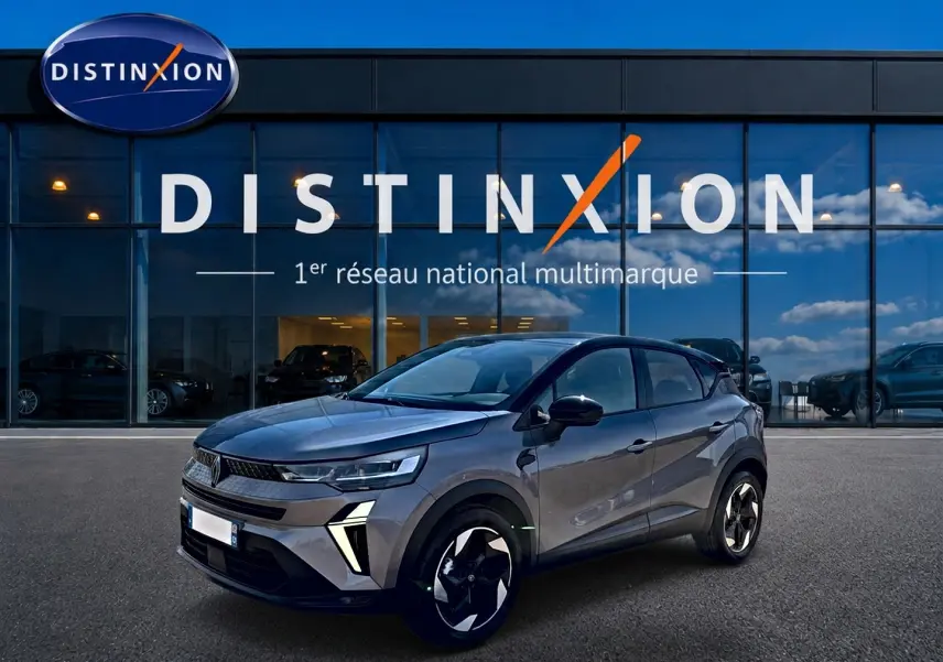 Renault Captur 2026 gris Cassiope toit noir en 3/4 avant droit, avec jantes alu et feux LED distinctifs.