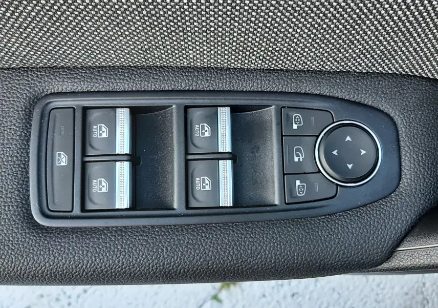 Panneau de commandes des vitres et rétroviseurs électriques sur la porte côté conducteur du Renault Captur noir métal 2024.