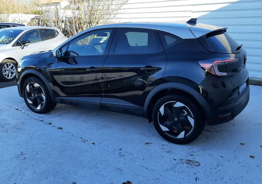 Renault Captur 2024 noir métal avec toit gris, vue de profil côté gauche, jantes noires distinctives et feux arrière LED.