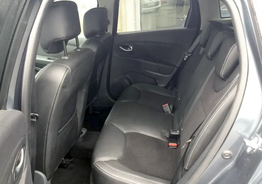 Vue intérieure côté arrière droit de la Renault Clio IV Estate gris titanium, sièges arrière en cuir noir avec surpiqûres blanches.