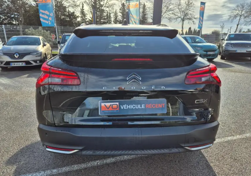 Vue arrière d'une Citroën C5 X noire 2024 avec feux LED et logo centré, stationnée en extérieur.