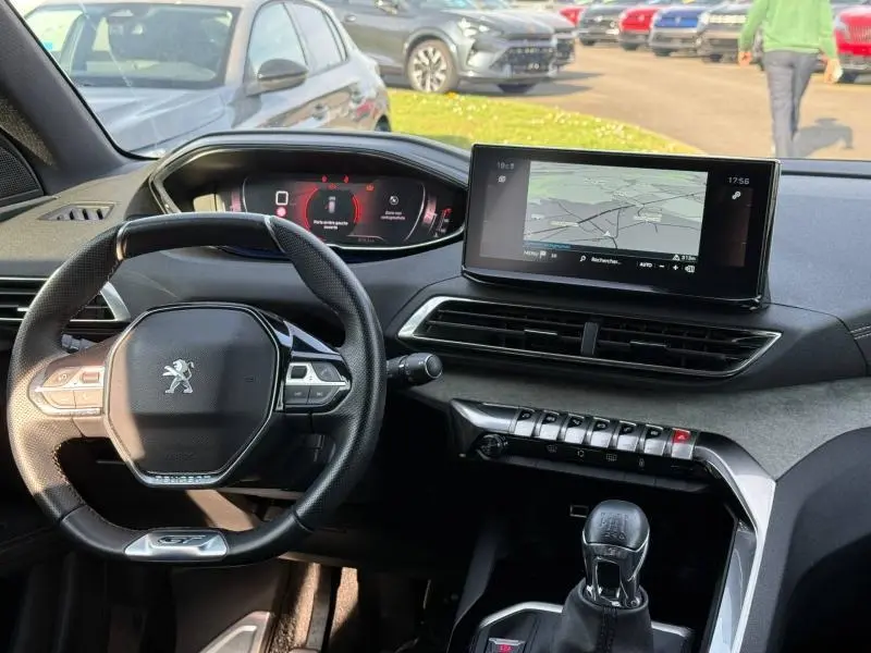 Vue intérieure du tableau de bord du Peugeot 3008 2024 GT, avec volant compact, écran tactile et levier de vitesses manuel.