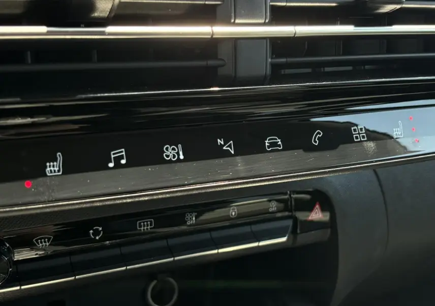 Détail du tableau de bord noir brillant du Citroën C5 Aircross Hybrid avec commandes tactiles et voyants rouges allumés.