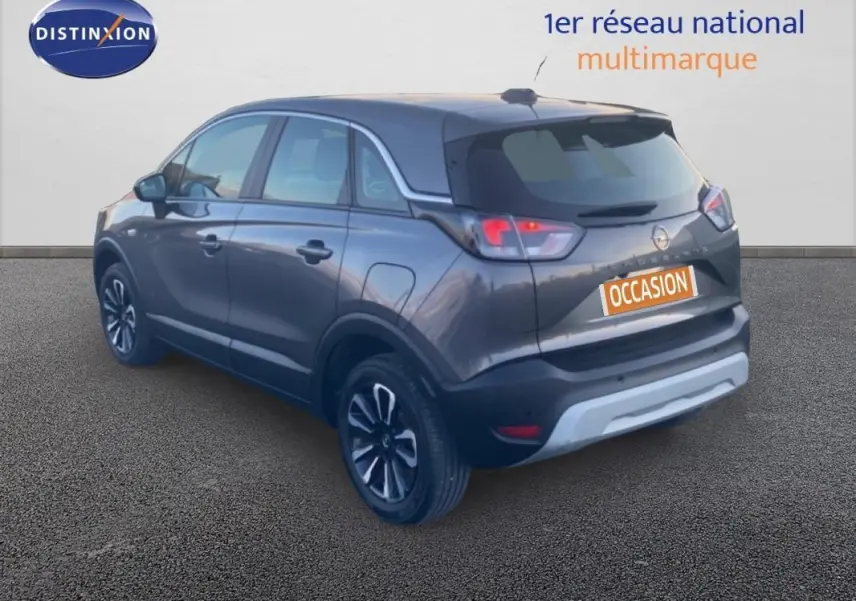 Vue 3/4 arrière d’un Opel Crossland gris foncé avec jantes alliage 17 pouces et toit panoramique visible.