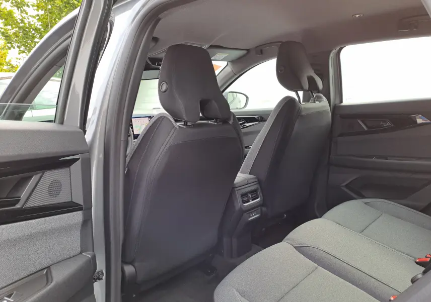 Intérieur arrière du Renault Austral gris schiste 2025, vue côté gauche montrant les sièges tissu noir et les aérateurs centraux.