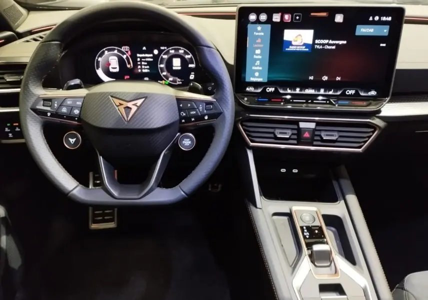 Vue intérieure frontale du tableau de bord et volant noir avec logo CUPRA cuivré, écran tactile HD et commandes modernes.
