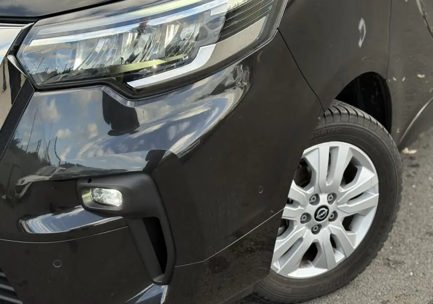 Gros plan sur l'avant droit noir métallisé du Nissan Primastar 2025 avec phare LED et jante alliage 17 pouces.