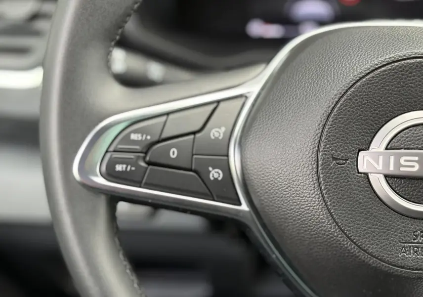 Gros plan sur le volant noir du Nissan Primastar 2025 avec commandes intégrées au volant côté gauche.