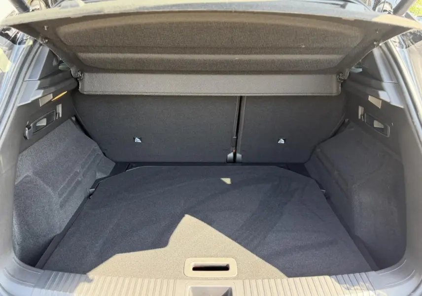 Vue intérieure du coffre ouvert du Renault Austral E-Tech Full Hybrid 2026, avec habillage gris foncé et cache-bagages déployé.