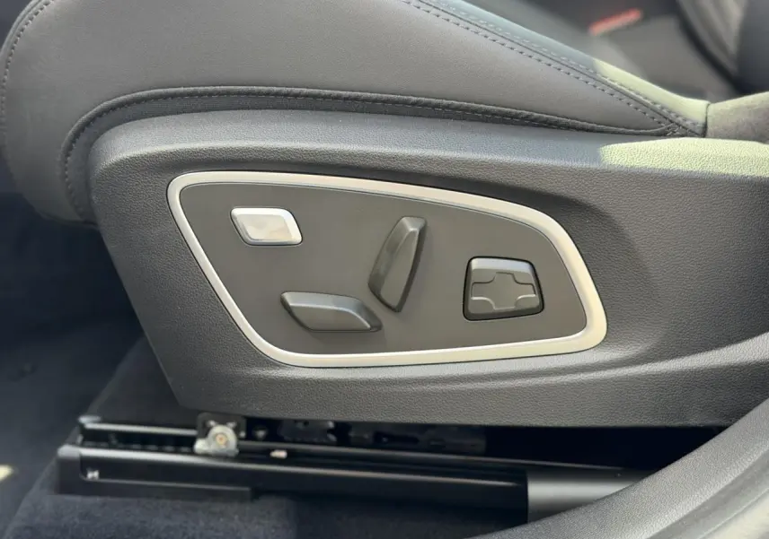 Gros plan sur les commandes électriques du siège conducteur en cuir noir du Renault Austral E-Tech Full Hybrid 2026.