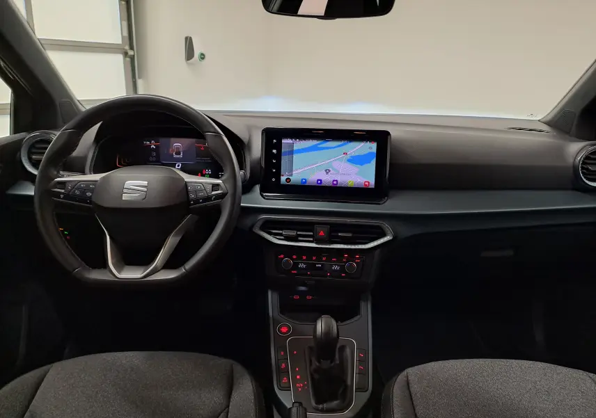Vue intérieure avant du tableau de bord et volant du SEAT Arona 2024, avec écran tactile et commandes au volant.