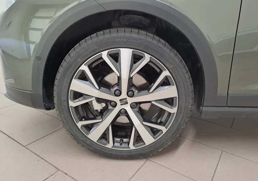 Gros plan sur la jante alliage 18'' PERFORMANCE Machined du côté avant droit d'un SEAT Arona gris falaise.