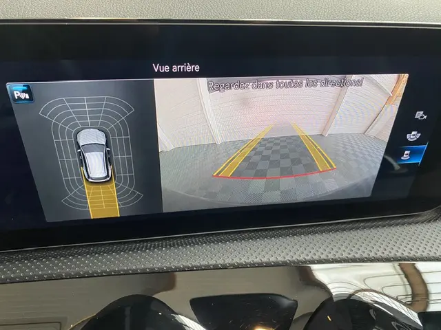 Écran tactile intérieur montrant la caméra de recul et les capteurs de stationnement du Mercedes CLA 200 d noir.