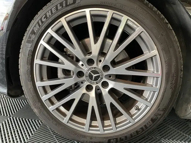Gros plan sur la jante alliage argentée et pneu Michelin d'une Mercedes CLA 200 d noire, mettant en valeur l'emblème central.
