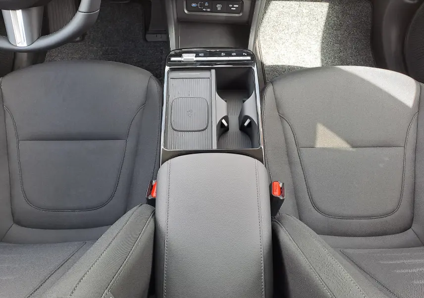 Vue intérieure centrée sur la console centrale et les sièges tissu noirs du Hyundai Tucson 2025 en Ecotronic Grey.