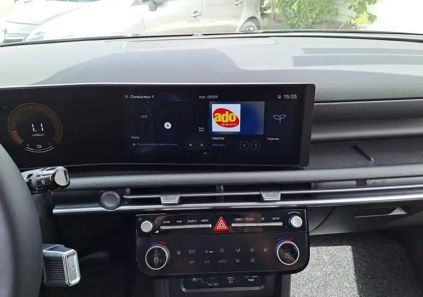 Intérieur du Hyundai Tucson 2025 en vue frontale, tableau de bord noir avec écran tactile et commandes climatisation digitales.