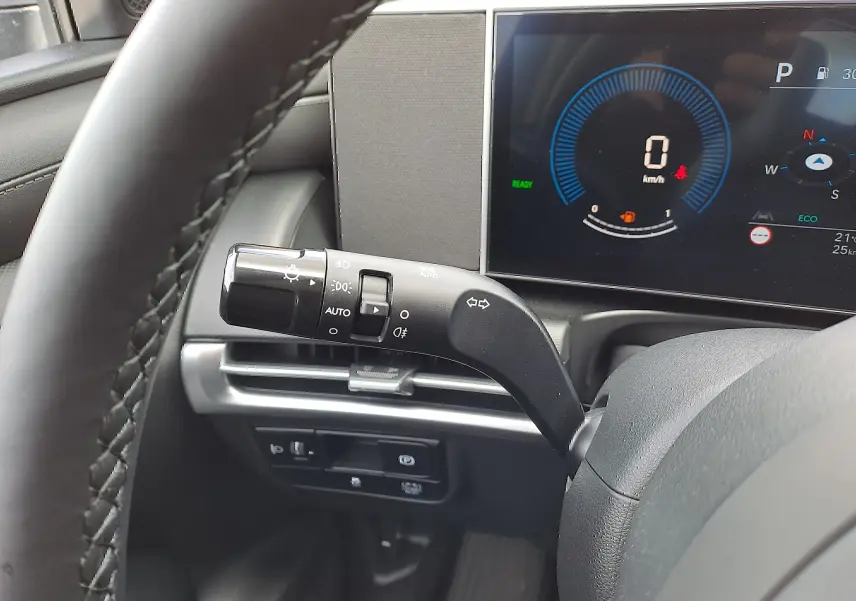 Gros plan sur la manette de clignotants à gauche du volant dans l'habitacle noir du Hyundai Tucson 2025.