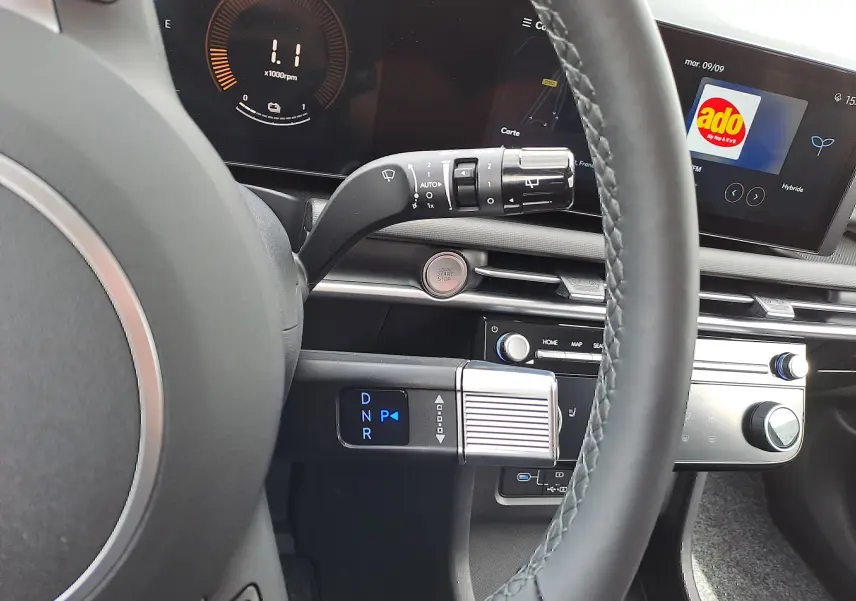 Vue intérieure du tableau de bord du Hyundai Tucson 2025 en gris, avec volant, écran digital et commandes modernes visibles.