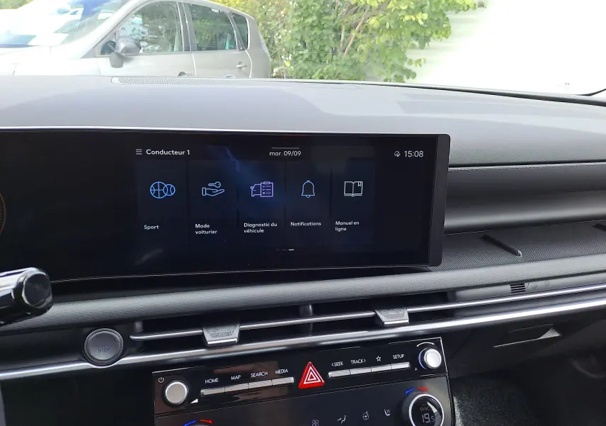 Vue intérieure du tableau de bord du Hyundai Tucson 2025 avec écran tactile central et commandes climatisation visibles.