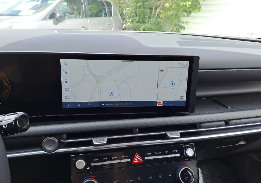 Vue intérieure du tableau de bord du Hyundai Tucson 2025 avec écran tactile affichant la navigation et commandes climatisation.