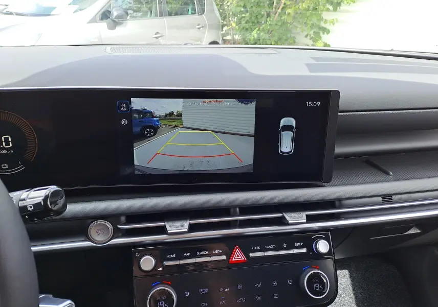 Vue intérieure du tableau de bord du Hyundai Tucson 2025, écran affichant la caméra de recul et commandes climatisation.