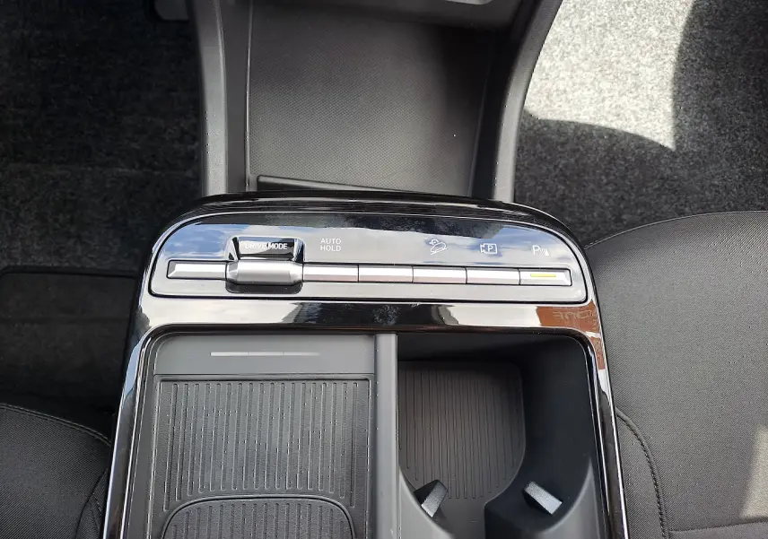 Vue plongeante sur la console centrale noire du Hyundai Tucson 2025, avec commandes de mode de conduite et porte-gobelets.