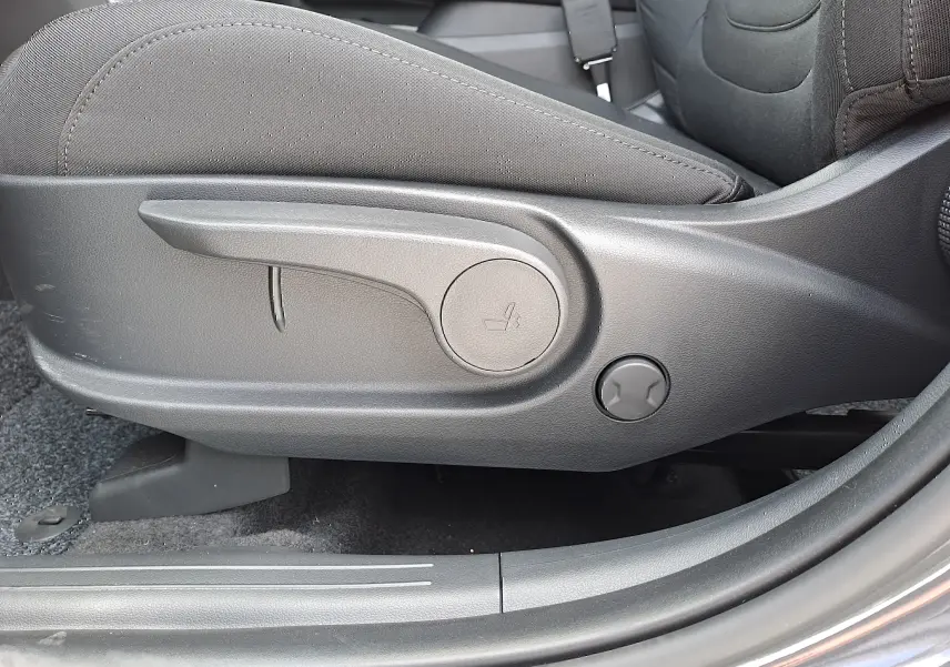 Gros plan sur le réglage manuel du siège avant en tissu noir du Hyundai Tucson 2025 couleur gris Ecotronic.