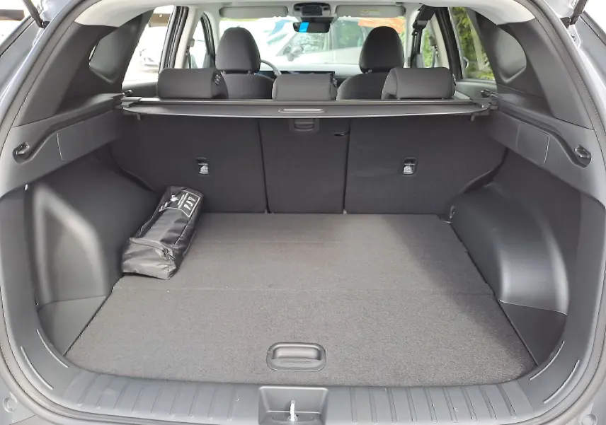 Coffre ouvert du Hyundai Tucson 2025 gris Ecotronic, vue arrière montrant l'espace de chargement et la plage arrière.