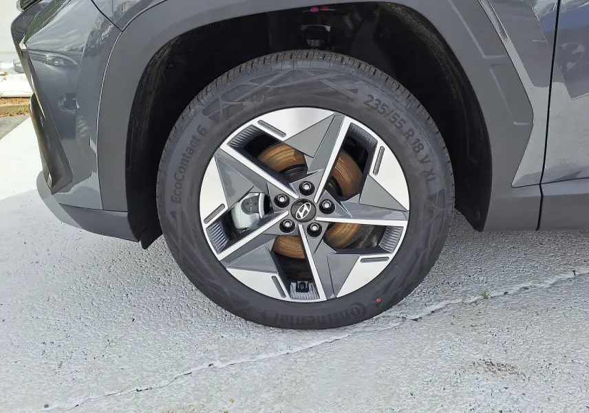 Gros plan sur la roue avant gauche du Hyundai Tucson 2025 gris Ecotronic avec jante alliage bicolore et logo Hyundai central.