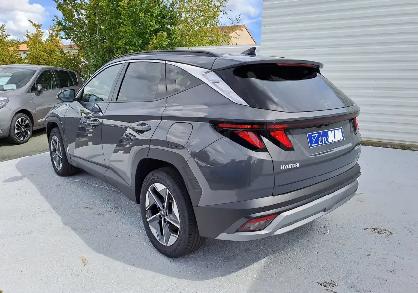 Vue 3/4 arrière droite du Hyundai Tucson 2025 gris Ecotronic avec feux arrière LED et jantes alliage bicolores.
