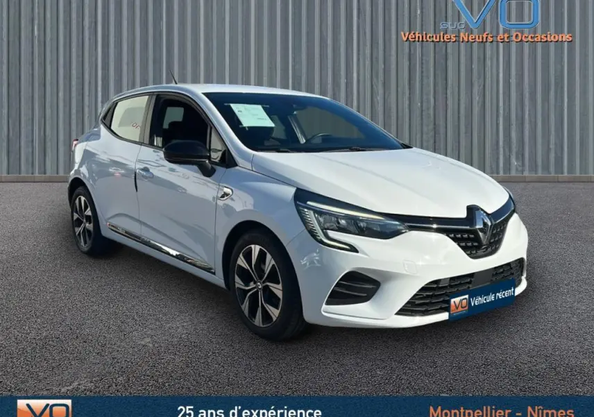 Vue 3/4 avant droite d'une Renault Clio blanche V TCe 90 - 21 Limited avec jantes alliage 16 pouces sur sol gris.