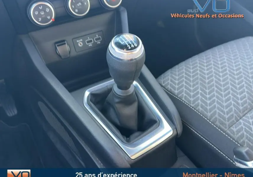 Le levier de vitesses manuel de la Renault Clio V TCe 90 blanc 2021 avec console centrale et siège tissu gris.