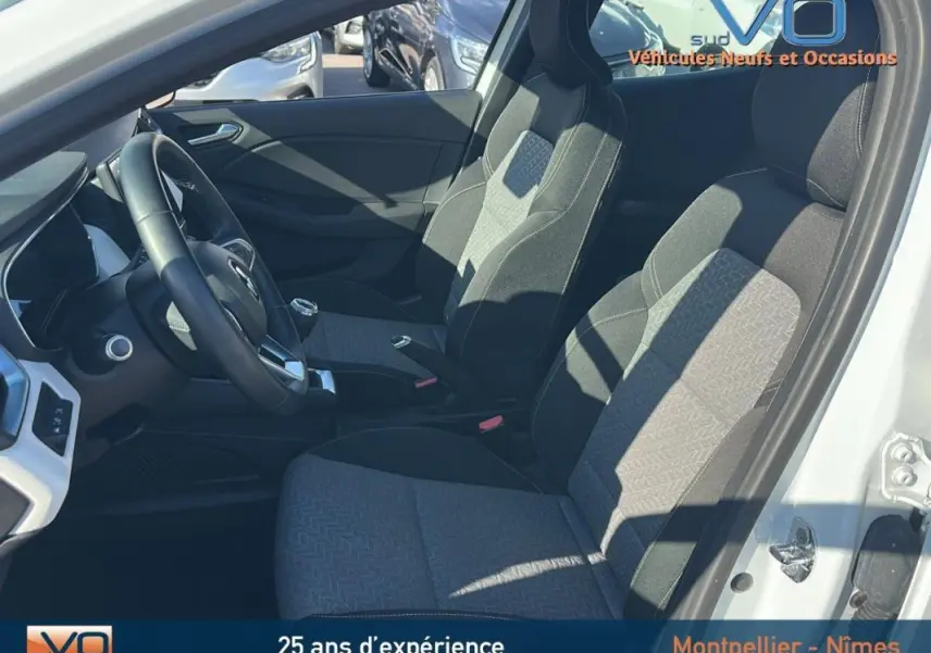 Intérieur de la Renault Clio blanc 2021, vue côté conducteur montrant sièges tissu gris et volant noir.