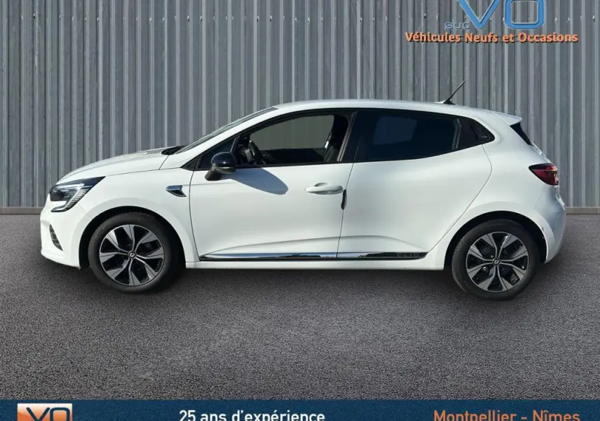 Profil côté gauche d'une Renault Clio blanche V TCe 90 - 21 Limited avec jantes alliage 16 pouces sur fond neutre.