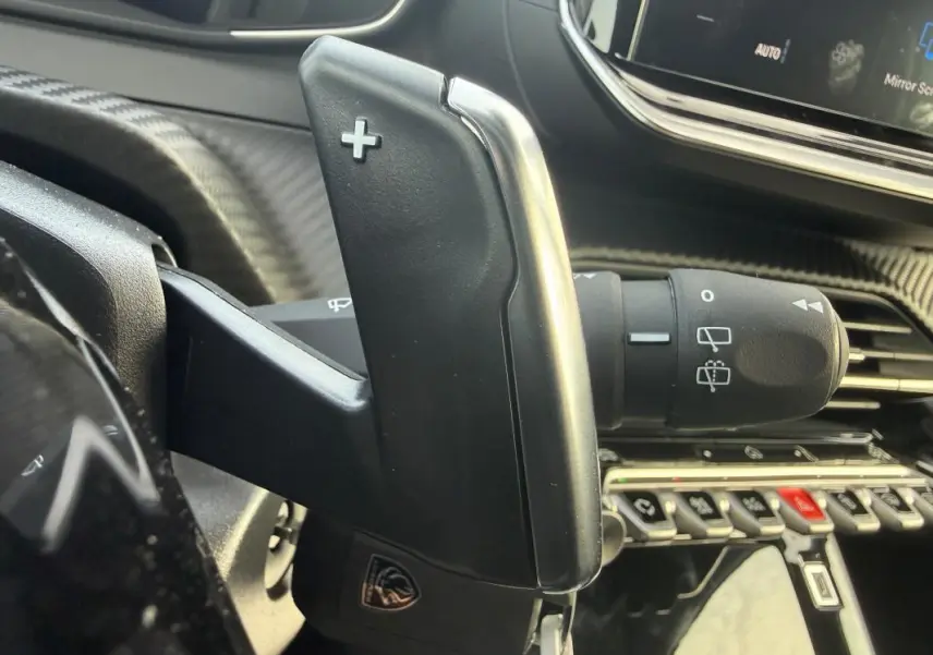Gros plan sur la palette de changement de vitesse droite dans l’habitacle gris d’une Peugeot 208 Hybrid 110 e-DCS6 Allure 2025.