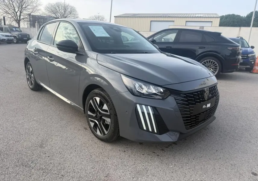 Peugeot 208 gris vue 3/4 avant droit, avec calandre noire et feux diurnes à LED distinctifs.