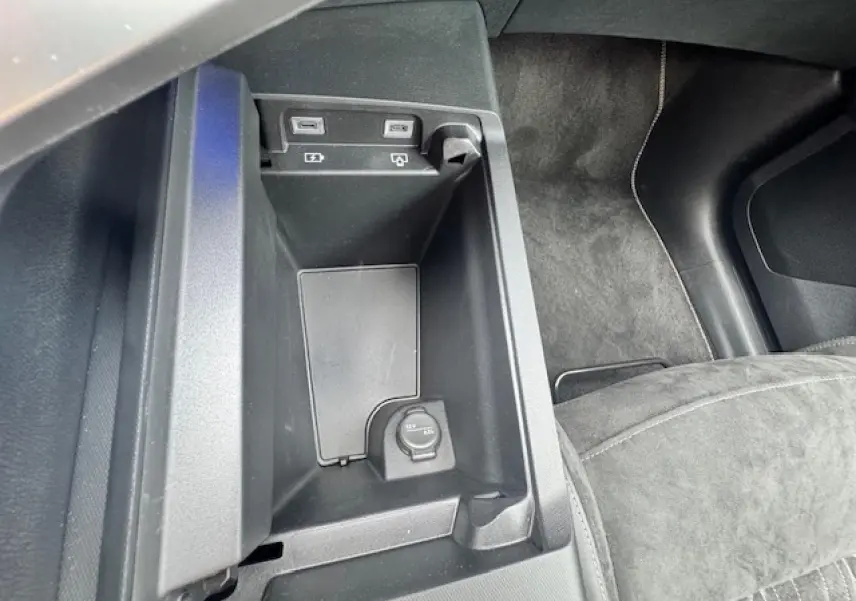 Vue rapprochée de la console centrale noire avec prises USB et prise 12V du Peugeot 5008 gris titane intérieur Alcantara.