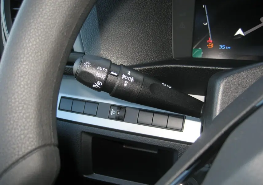 Gros plan sur la manette de commandes d'éclairage à gauche du volant dans l'habitacle du Peugeot Expert Fourgon blanc.