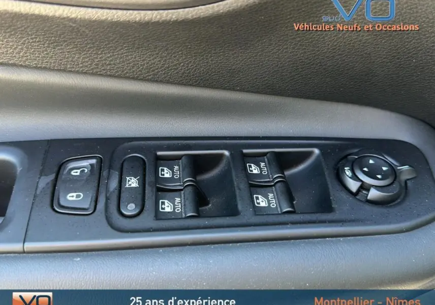 Gros plan sur les commandes des vitres électriques et rétroviseurs d'un Jeep Renegade noir 2024, côté conducteur.