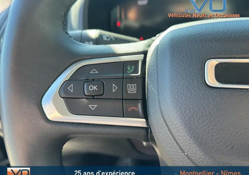 Gros plan sur les commandes du volant noir du Jeep Renegade 2024, avec boutons multifonctions et finition argentée.
