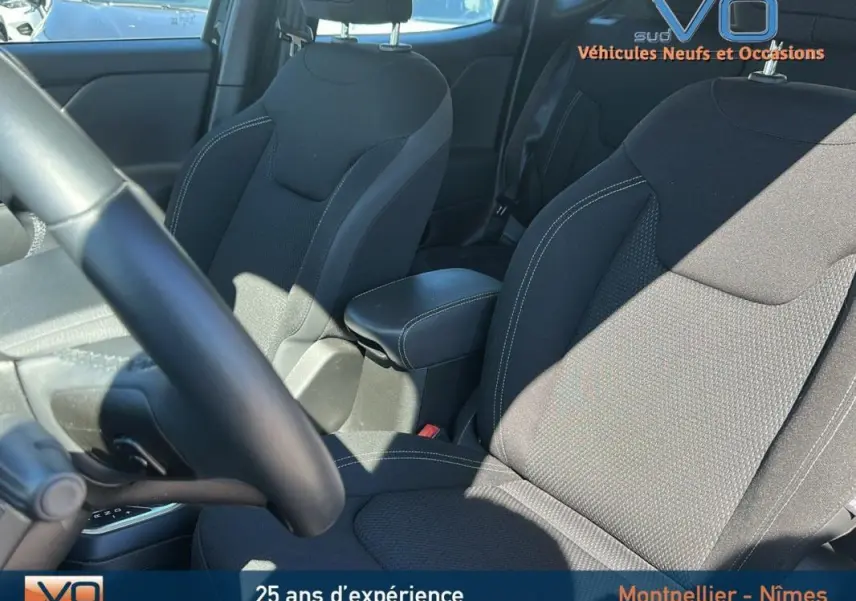 Intérieur du Jeep Renegade noir 2024, vue sur sièges avant avec accoudoir central et volant partiel.