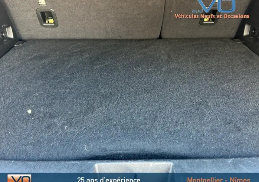 Espace de coffre noir du Jeep Renegade 2024, finition Summit, montrant la moquette et les fixations arrière.
