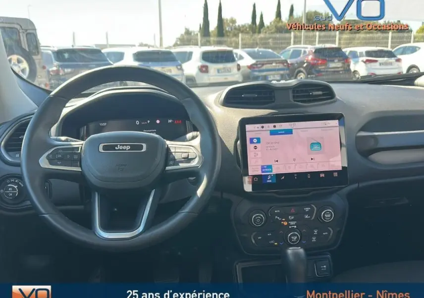 Vue intérieure du tableau de bord du Jeep Renegade 2024 noir, avec écran tactile central et volant multifonction.