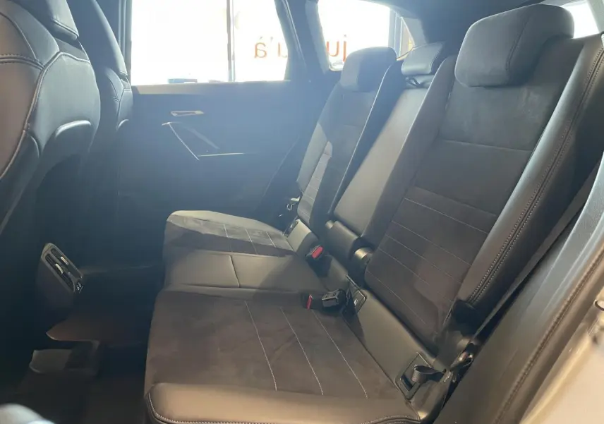 Vue latérale intérieure des sièges arrière en Alcantara noir avec surpiqûres bleues du BMW X1 xDrive20d 2024 Spacesilber Metallic.