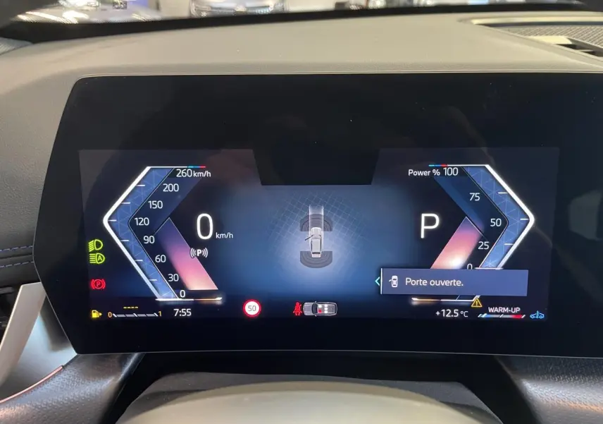 Tableau de bord numérique du BMW X1 xDrive 20d 2024 affichant vitesse, puissance et alerte porte ouverte.