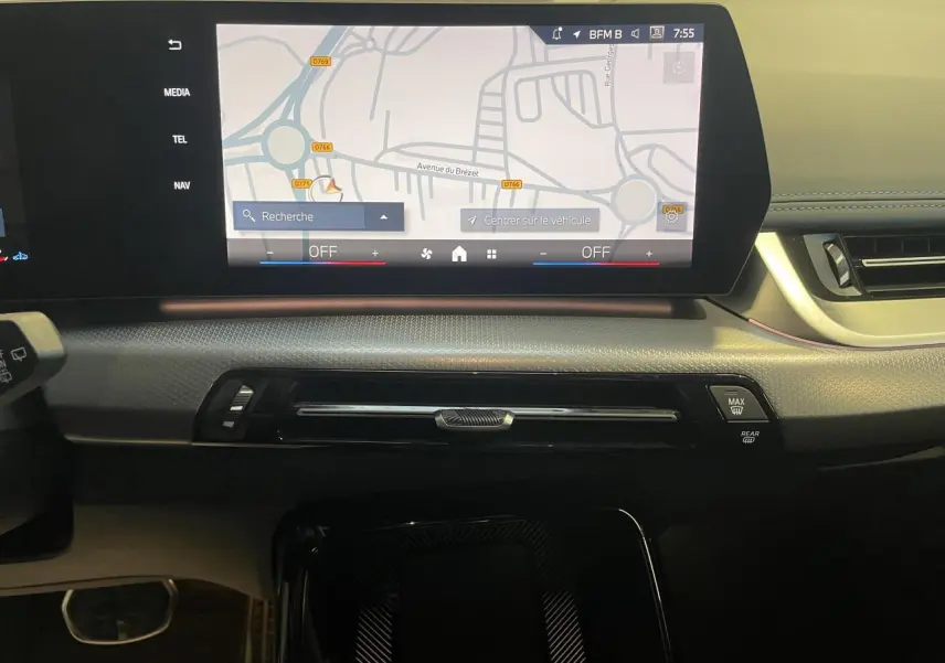 Vue intérieure du tableau de bord du BMW X1 2024 avec écran tactile incurvé affichant la navigation et finition noire élégante.