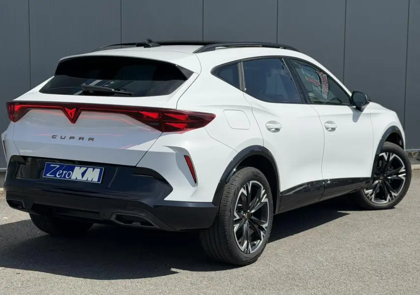 Vue 3/4 arrière droite d'une CUPRA Formentor blanc Neige avec signature lumineuse Tri-LED et jantes alliage noires.
