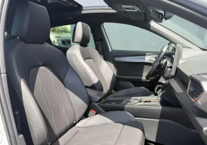 Vue intérieure côté conducteur du CUPRA Formentor blanc Neige 2025, sièges avant en cuir et alcantara avec toit ouvrant panoramique.